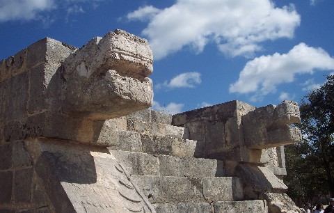 Photo of serpent heads at Chichen Itza goes here.