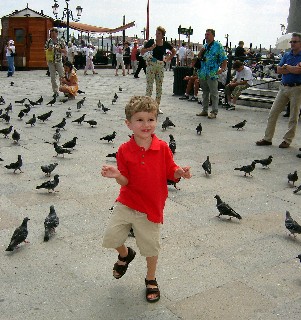 Photo of Aiden in St. Mark's Square with pigeons goes here.