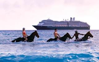 Photo of horseback riders in the surf at Half Moon Cay. 