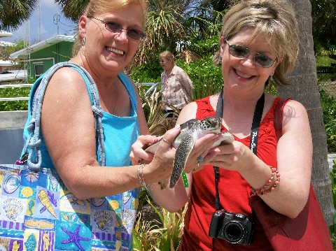 Photo of Nancy (left) and Shelley at the Grand Cayman Turtle Farm goes here. 