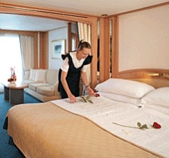 Photo of Seabourn Cruise Line's cabin stewardess making up the bed goes here.