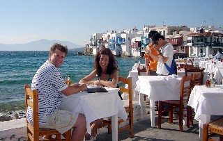 Photo of Veronica and Kyle in a romantic dining spot in Mykonos goes here.