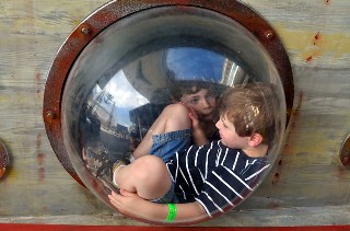 Photo of kids in the port hole of a pirate ship goes here.*