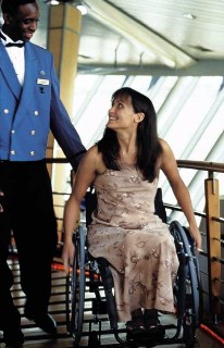 Photo of woman in wheelchair with a crew member assisting goes here.